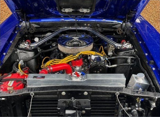 Modified V8 engine bay on a blue muscle car
