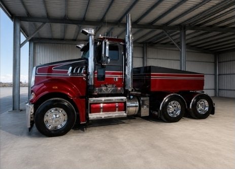 Modified red prime mover in a shed awaiting HVRAS inspection